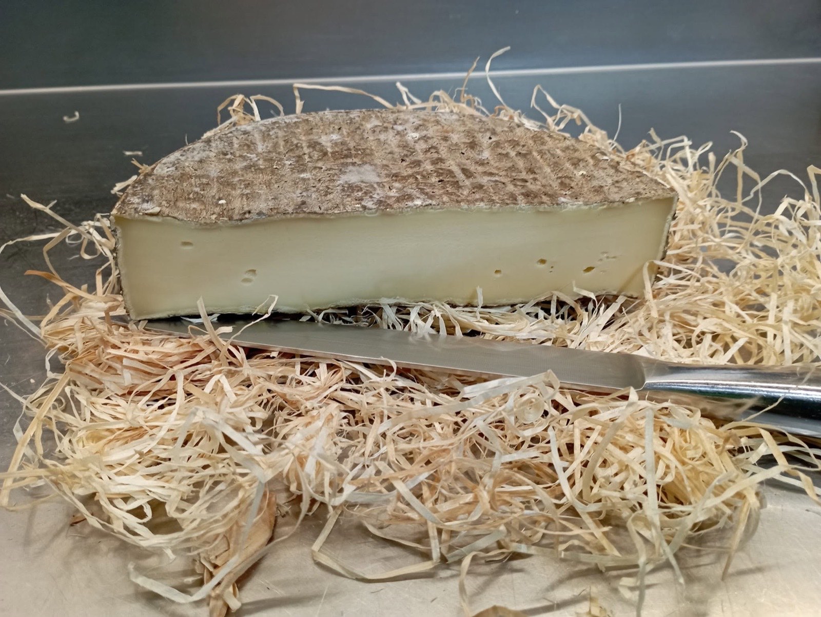 Saint-Nectaire fermier tranché sur un lit de paille
